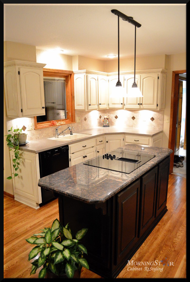 Off-white painted and glazed kitchen cabinets with a black refinished island.